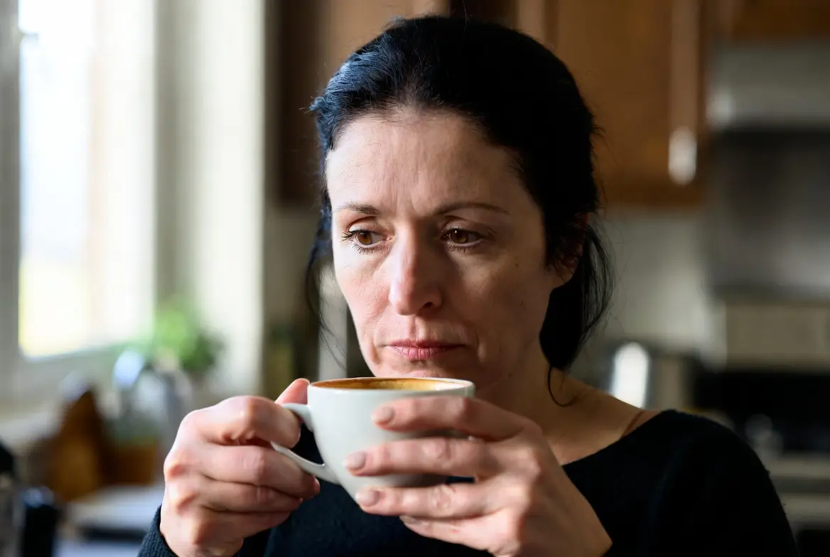 ondas de calor na menopausa — mulher segurando xícara de café em momento de atenção ao próprio corpo